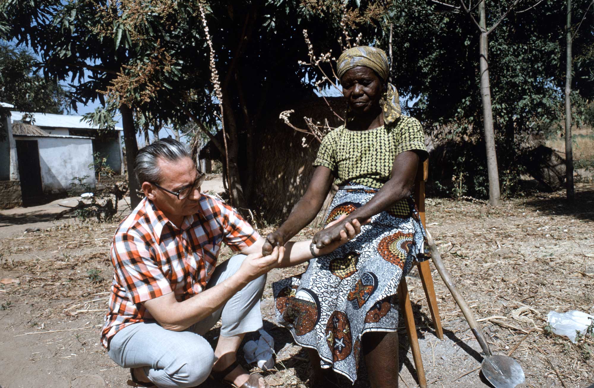 9 Père Pierre examine une lépreuse au Cameroun